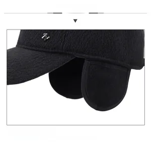 Dettaglio del cappello invernale nero con paraorecchie caldi e logo ancora in metallo