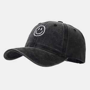 Detail view of washed cotton baseball cap with embroidered smiley face on charcoal gray