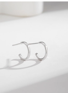 Detailed macro view showing the high-polished surface of C-shaped S925 silver stud earrings