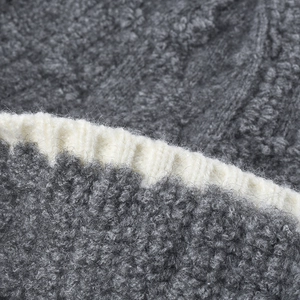 Close-up of thick grey and off-white boucle knit beanie with ribbed hem detailing