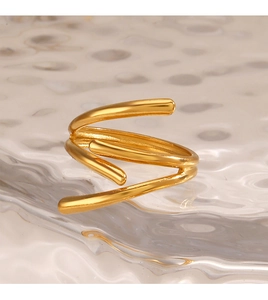 Detail of a gold-plated triple spiral open ring on ripple glass with warm lighting