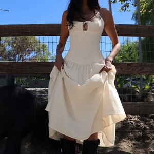 Détail d'une robe midi blanc crème chic avec design ajouré et jupe longue plissée
