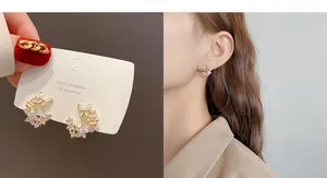 Detail of S925 silver needle butterfly and flower earrings with pink petals and zircons
