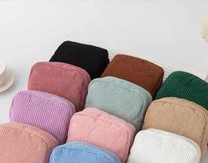 Detailed macro view showing a variety of colorful corduroy makeup storage bags stacked