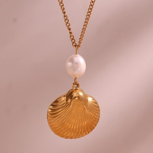 Detailed close-up of an 18K gold plated necklace with a freshwater pearl and shell pendant