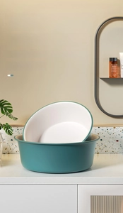 Detail of stacked green and white washbasins with premium matte finish and rounded edges