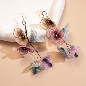 Detailed view of handmade fabric flower tassel earrings with glass beads and gold hooks