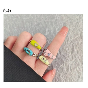 Detail of four colorful dopamine enamel rings with zircon heart and bow decorations