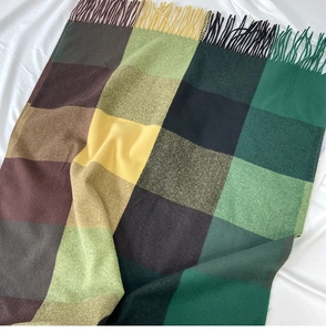 Detail of plaid scarf texture in green and yellow with soft frayed tassel edges