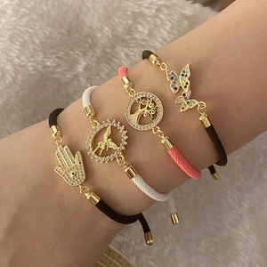 Set of four adjustable woven bracelets with gold charms like Hamsa and Butterfly