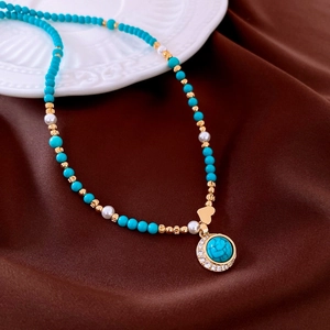 Detail of 18K gold plated necklace featuring turquoise beads, pearls and heart pendant