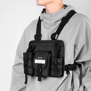 Detail of black tactical chest bag with MOLLE system and reflective safety stripe