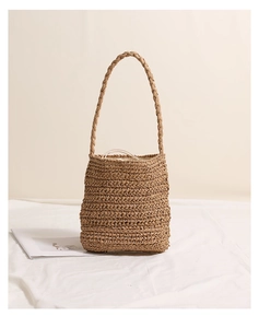 Close-up of handmade daisy straw shoulder bag with woven handle and drawstring lining