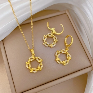 Elegant gold necklace and earring set with zircon-inlaid circles on white silk