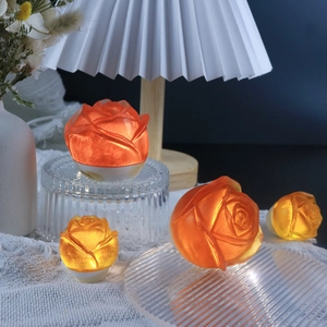 Rose shaped LED night light in warm orange and yellow resin with a round base