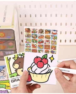 Detail of hands coloring a cupcake drawing with an acrylic marker in a kid coloring book