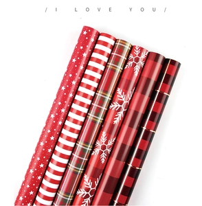 Set of 6 rolls of red Christmas gift wrapping paper with star, stripe, and plaid patterns