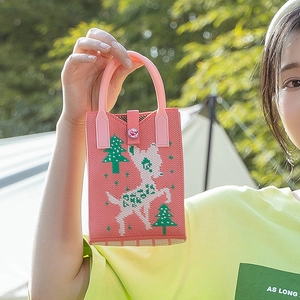 Pink knitted tote bag with deer pattern and LOVE button shown in outdoor camping setting