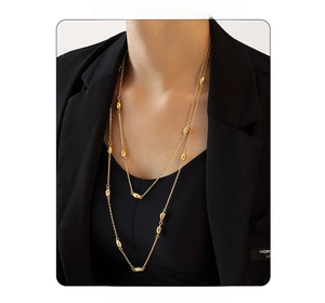 Close-up of double-layered gold titanium sweater chain with beads on a black blazer