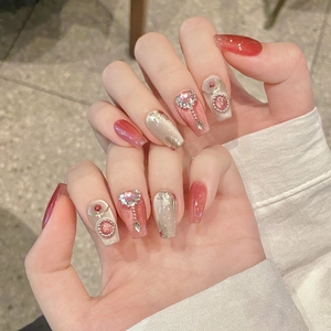 Pink cat-eye gradient press-on nails with luxury rhinestones and gold leaf accents