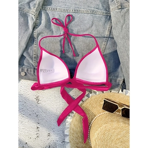 Detailed view of fuchsia halter bikini top with 80% nylon and 20% spandex care label