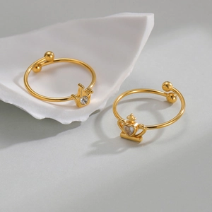 Luxury gold crown open rings with sparkling crystals and heart-shaped gems on a white shell
