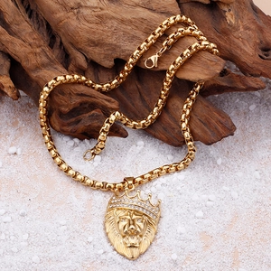 Detail of gold lion head pendant with crown and rhinestones on a box chain