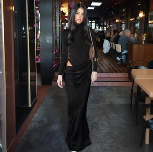 Vestido largo negro ajustado de manga larga con cuello alto y detalles de aberturas