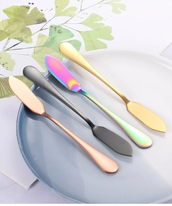 Couteaux à beurre colorés en acier inoxydable en or, or rose et noir sur une assiette