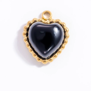Macro detail of heart-shaped 18k gold plated steel pendant with black obsidian stone