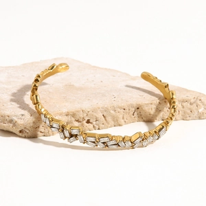 Détail d'un bracelet jonc doré minimaliste orné de zircons baguettes irréguliers