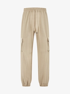 Detail of light khaki cargo pants showing drawstrings and textured striped fabric texture