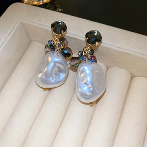 Macro view of baroque pearls and faceted dark gemstones in a jewelry box