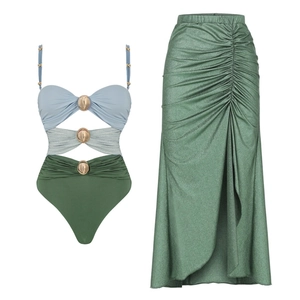 Detail of three-tone cutout swimsuit with gold buckle and green metallic pleated skirt