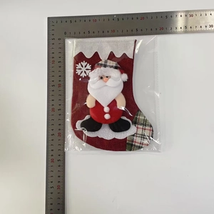 Détail d'une botte de Noël en toile de jute rouge avec Père Noël 3D et flocon brodé