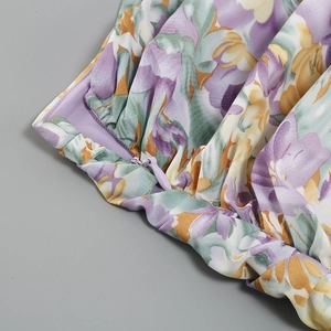 Detail of floral printed dress featuring a purple invisible zipper and soft chiffon texture