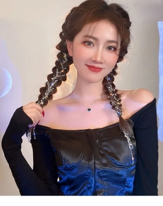Detailed view of silver star hair chain with crystals on braided hair and heart pendant necklace