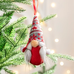 Handmade Christmas gnome hanging ornament with red knitted hat on a decorated tree