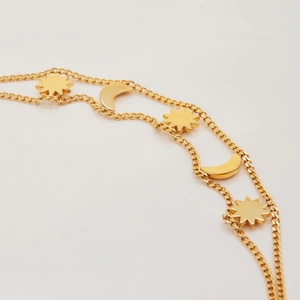 Macro detail of 18K gold plated stainless steel double chain with star and moon charms