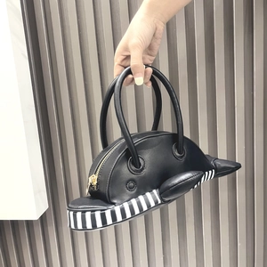 Close-up of black PU leather dolphin handbag with black and white striped detail