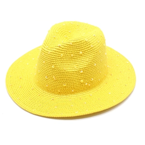 Close-up of bright yellow straw Panama hat featuring shimmering rhinestone decorations