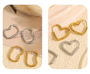 Detail shot of heart-shaped and irregular geometric earrings in gold and silver finishes