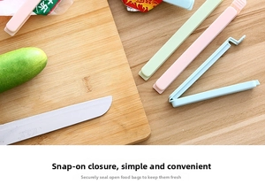 Macro detail of large pastel food bag clips on a wooden surface for kitchen storage