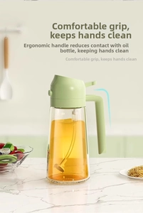 Detail showing the ergonomic light green handle and glass body of the spray oil bottle