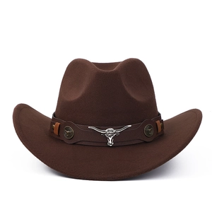 Détail d'un chapeau de cowboy en feutre marron avec tête de taureau argentée sur ruban