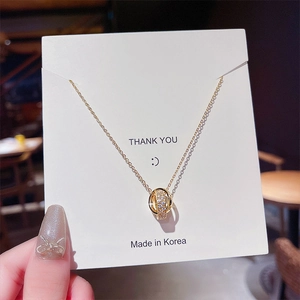 Macro view of interlocking lucky rings necklace with pavé cubic zirconia on card