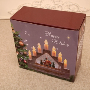 Detail view of the festive red Christmas candle light packaging box with Happy Holiday text