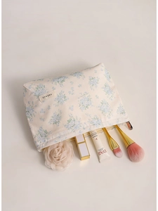 Floral canvas makeup bag with blue flower pattern on beige background and top zipper
