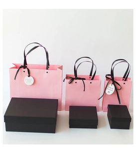 Detailed view of pink gift bags and black boxes in three sizes for gift packaging