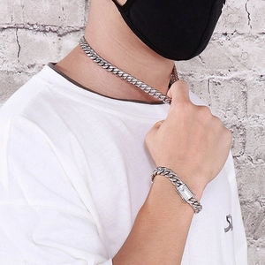 Polished silver Cuban link chain necklace and bracelet set worn by a male model